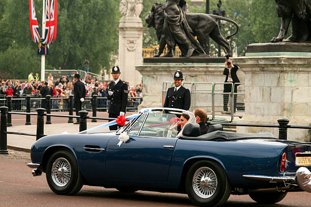 Royal Wedding London, United Kingdom - April 29, 2011: Prince William, Duke of Cambridge, and Kate, Duchess of Cambridge in their wedding car outside Buckingham Palace before its procession up The Mall. They are surrounded by police and security guards, and beyond, hundreds of well-wishers. Thousands of people from around the world flocked to London to witness the Royal Wedding. duchess photos stock pictures, royalty-free photos & images