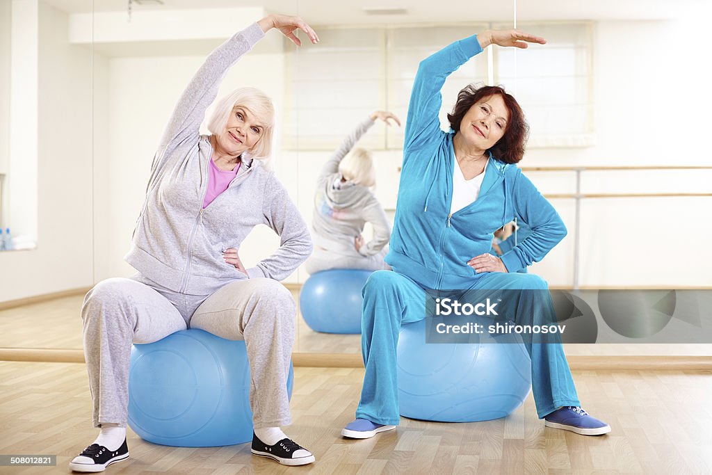 Workout Portrait of sporty females doing physical exercise on balls in sport gym Active Lifestyle Stock Photo