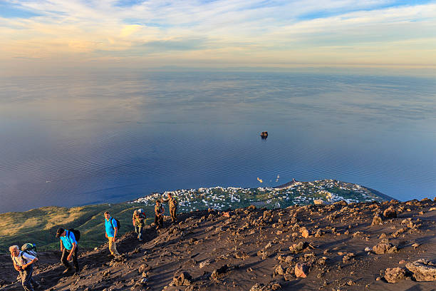 Stromboli, Italy - May 11, 2014: People climb the volcanic ridge of Stromboli at sunset. The island contains an active volcano, and this hike, that reaches the top of the volcano, is the most popular of the Aeolian archipelago.