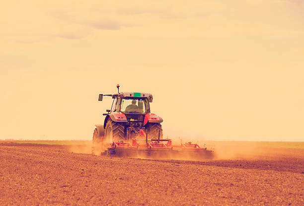 istock Red tractor driven by farmer cultivating land at spring 508013619