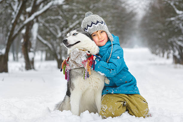 istock happy boy hugging dog or husky outdoors in winter day 508024658