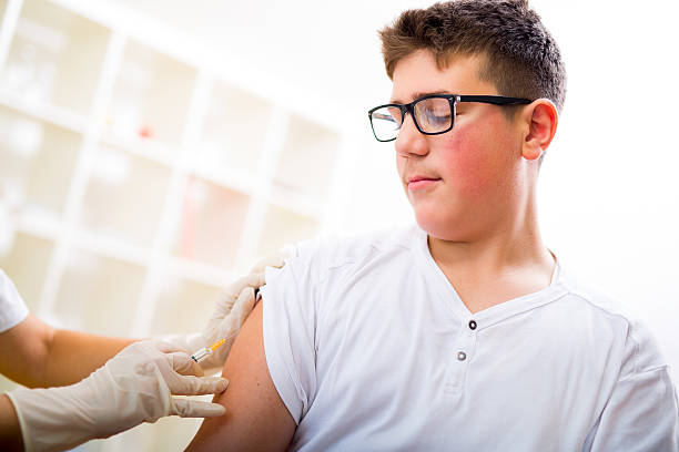 Teenage boy getting vaccination in his arm Teenage boy getting vaccination in his arm tetanus photos stock pictures, royalty-free photos & images