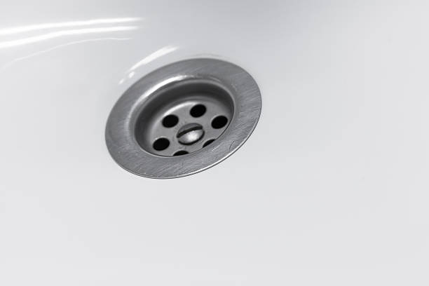istock Standard round drain hole in white domestic sink, macro 508025792