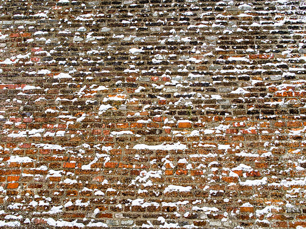 istock Wide red brick wall covered with snowflakes 508027648