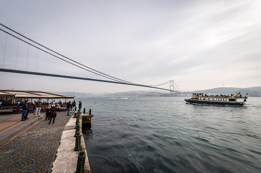 Istanbul, Turkey - January 31, 2016: People are making photos on the background of Bosphorus bridge in Istanbul, Turkey