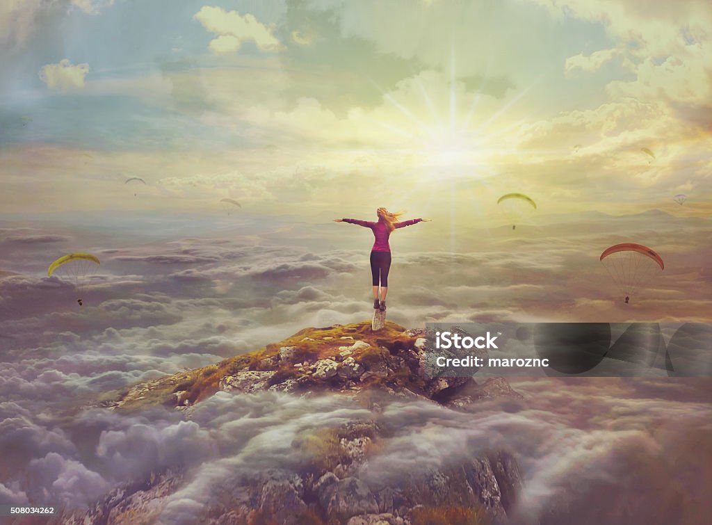 Young woman   standing on a rock with divorced hands Young woman in the sky  standing on a rock with divorced hands Mountain Stock Photo