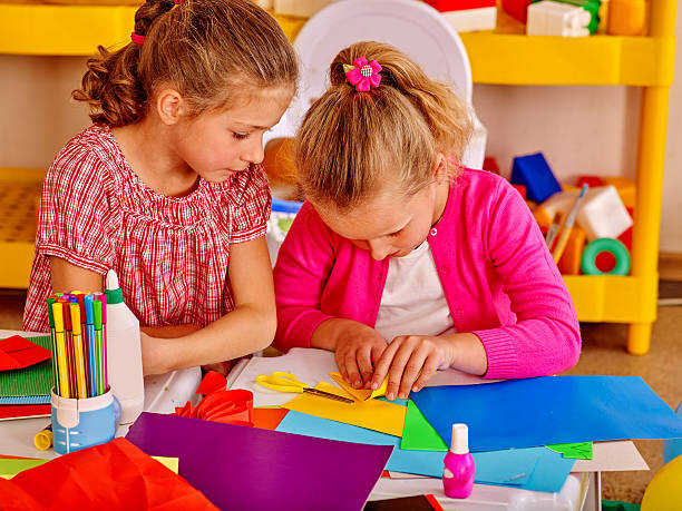 istock Kids holding colored paper on table in kindergarten 508035248