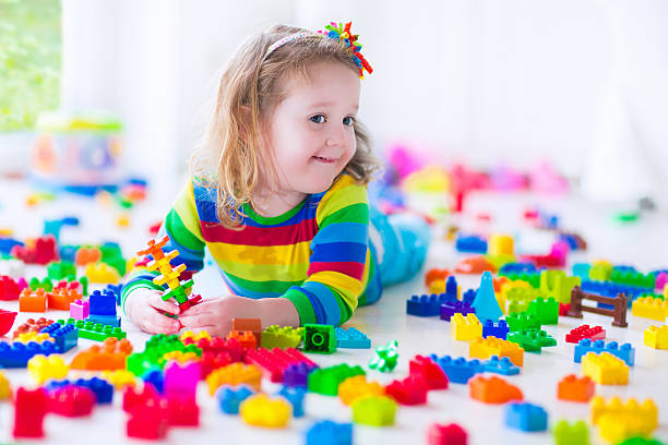 istock Little girl playing with colorful toy blocks 508037708