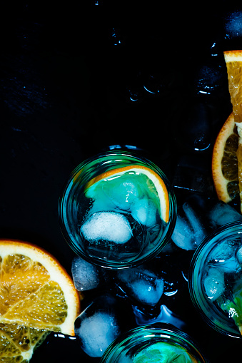 Blue cocktail with blue curacao liqueur and orange, top view, selective focus