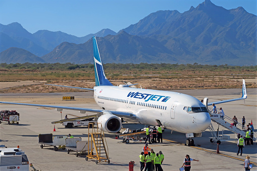 Luang Prabang Airport, Luang Prabang, Laos - March 22th 2023: Ground staff waiting beside an ATR72-600 from Lao Airlines in front of the runway at the airport in the former capital of Laos