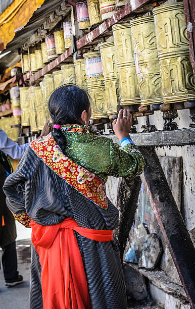 Midsection of woman holding hand prayer wheel and prayer beads