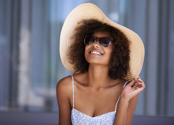 I finally get to wear this hat! Shot of an attractive young woman wearing a sun hat relaxing outside sun hat stock pictures, royalty-free photos & images