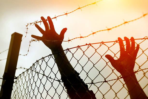 istock Refugee men and fence 508053220