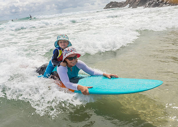 istock Mother Taking Her Young Child Surfing at the Beach 508056290