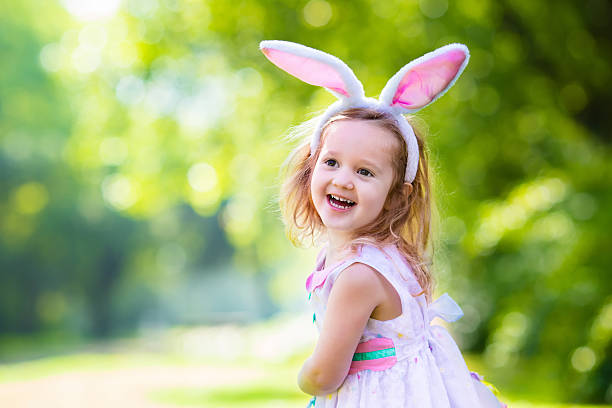 маленькая девочка с белой доской для пасхального приветствия - child easter flower little girls стоковые фото и изображения