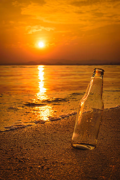istock Glass bottle on the sand at sunset. 508061834