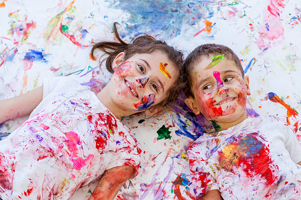 развлечения детей рисование пальцами брат и сестра - child multi colored painting art стоковые фото и изображения