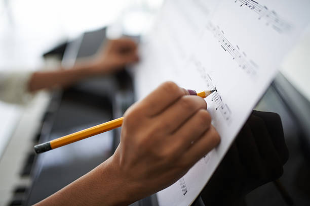 Female composer Close-up of female hands correcting music score composition stock pictures, royalty-free photos & images