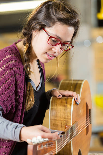 istock Young woman repairs guitar 508067830
