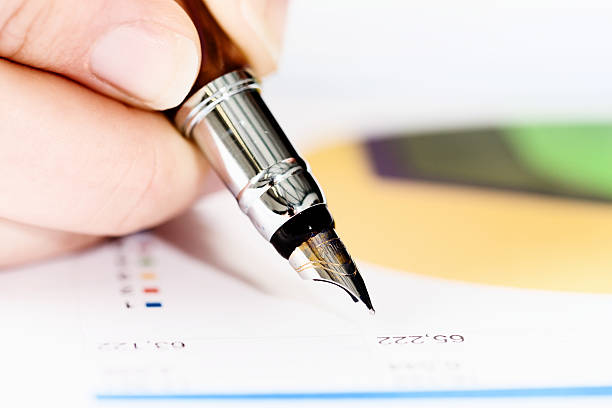 istock Hand checking spreadsheet with fountain pen, pie chart in background 508070775