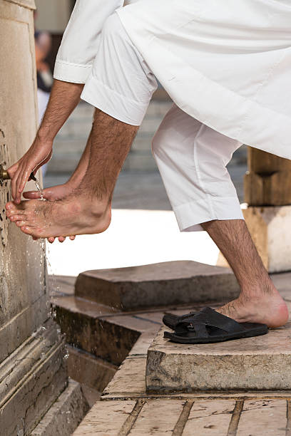 Izmir,Turkey - March 12, 2011: Faithful Muslims wash their feet at the mosque fountain, before go inside the Mosque and ritual worship.