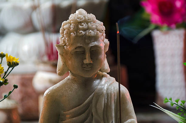 istock single marble Buddah holding a incense stick, Laos 508073939