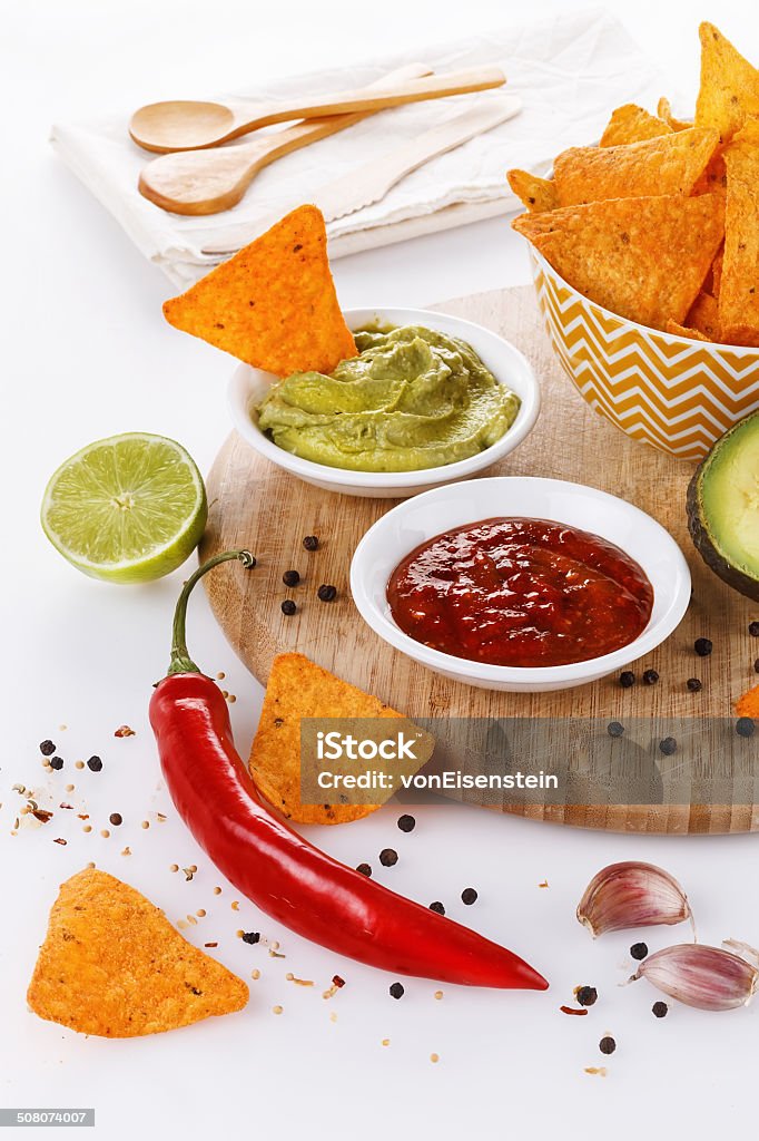 Mexican food concept â Doritos, guacamole and salsa Mexican food concept: doritos, guacamole and salsa over white background Appetizer Stock Photo