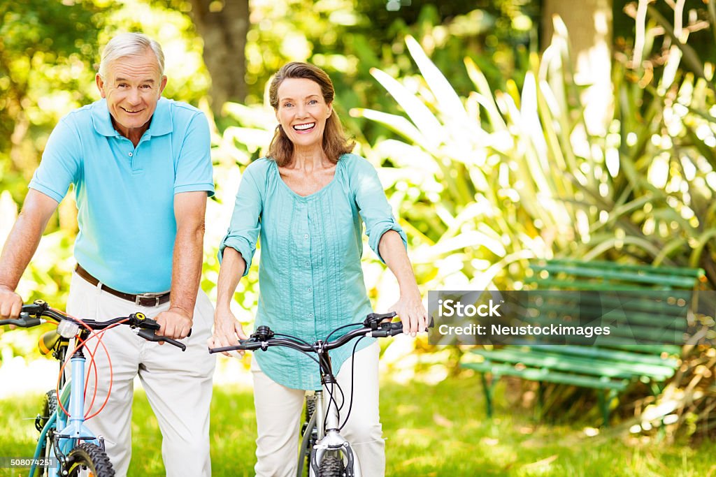 Couple Senior tenant des vélos dans le parc - Photo de 60-64 ans libre de droits