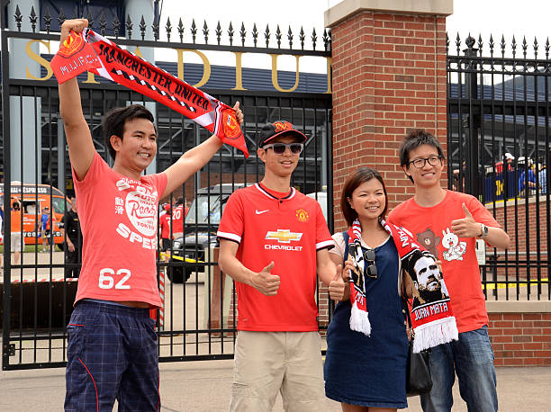 Manchester United fans at the stadium Ann Arbor, MI, USA - August 2, 2014: Manchester United fans get their pictures taken outside Michigan Stadium at the International Champions Cup game on August 2, 2014 in Ann Arbor, MI. michigan football stock pictures, royalty-free photos & images