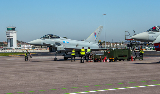 Southend on sea, Essex, UK- May 27, 2012: RAF Eurofighter typhoon being made ready for take off by 5 ground craw. ATC Tower in the background