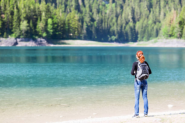 istock Woman with backpack on the lake 508077433