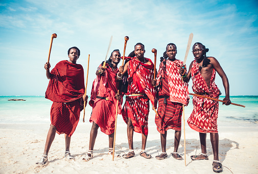 Masai warriors in traditional clothing demonstrating their weapons on the beach (Zanzibar, Africa).