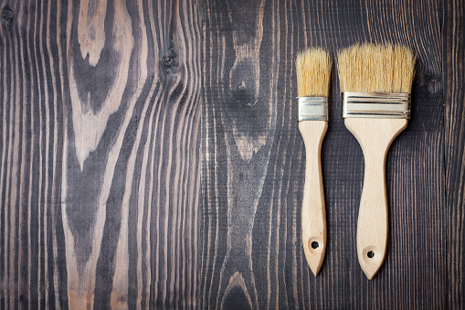 Two paint brushes on old wooden background