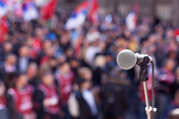 Protest. Public demonstration. Microphone in focus against unrecognizable crowd political rally stock pictures, royalty-free photos & images