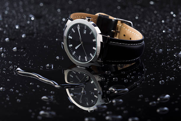 Golden wristwatch with a visible clockwork on black background.