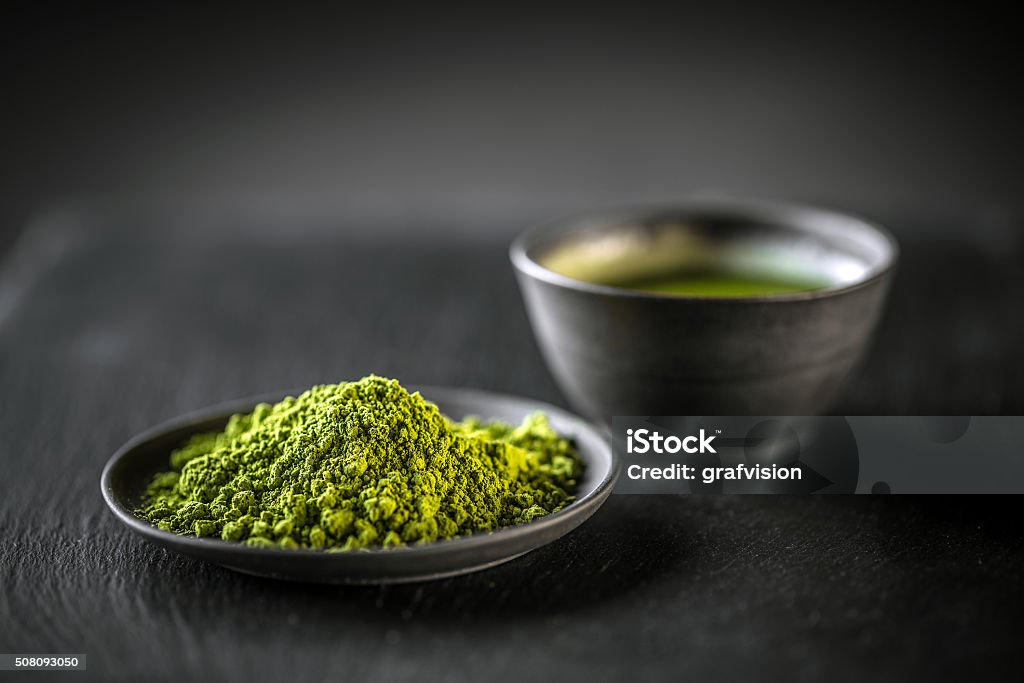 Matcha, powder green tea Matcha, powder green tea in black plate Matcha Tea Stock Photo