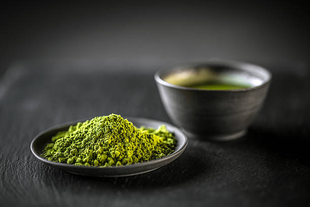 Matcha, powder green tea Matcha, powder green tea in black plate green tea powder stock pictures, royalty-free photos & images