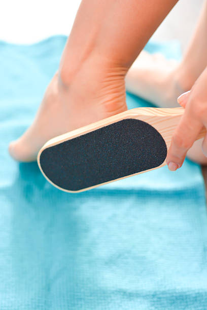 Woman Using Foot File For Removing Dead Skin From Feet In Bathroom Closeup  Stock Photo - Download Image Now - iStock