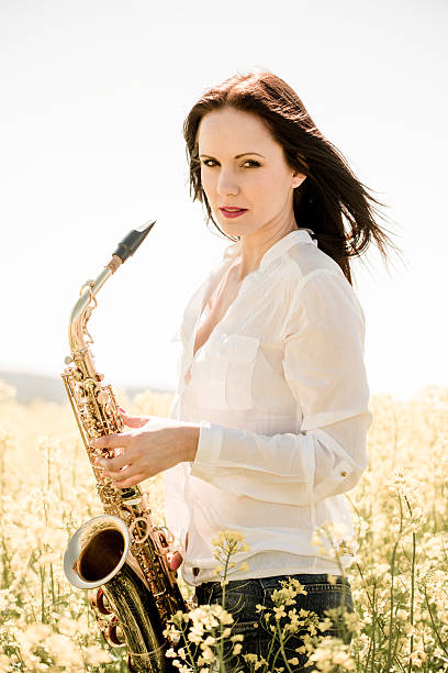 Woman with saxophone in rapeseed field