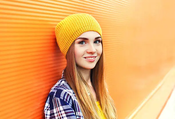 Photo of Portrait closeup beautiful young girl in yellow hat over colorful