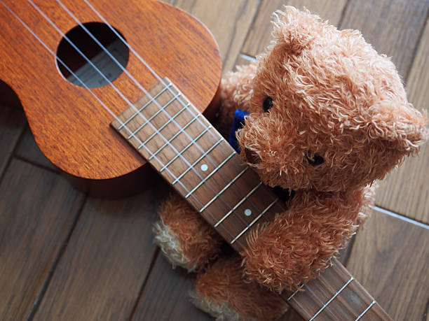 istock Lovely Brown Bear Sitting along with Ukulele 508105258