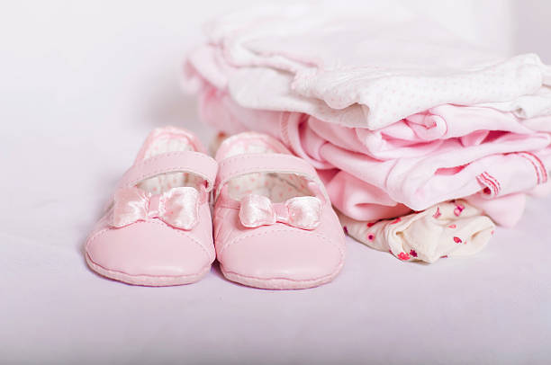 little pink baby shoes and  clothes stock photo