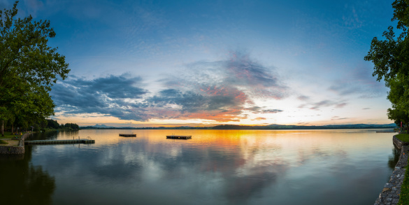 panorama of lake wallersee at sunset with trees and clouds