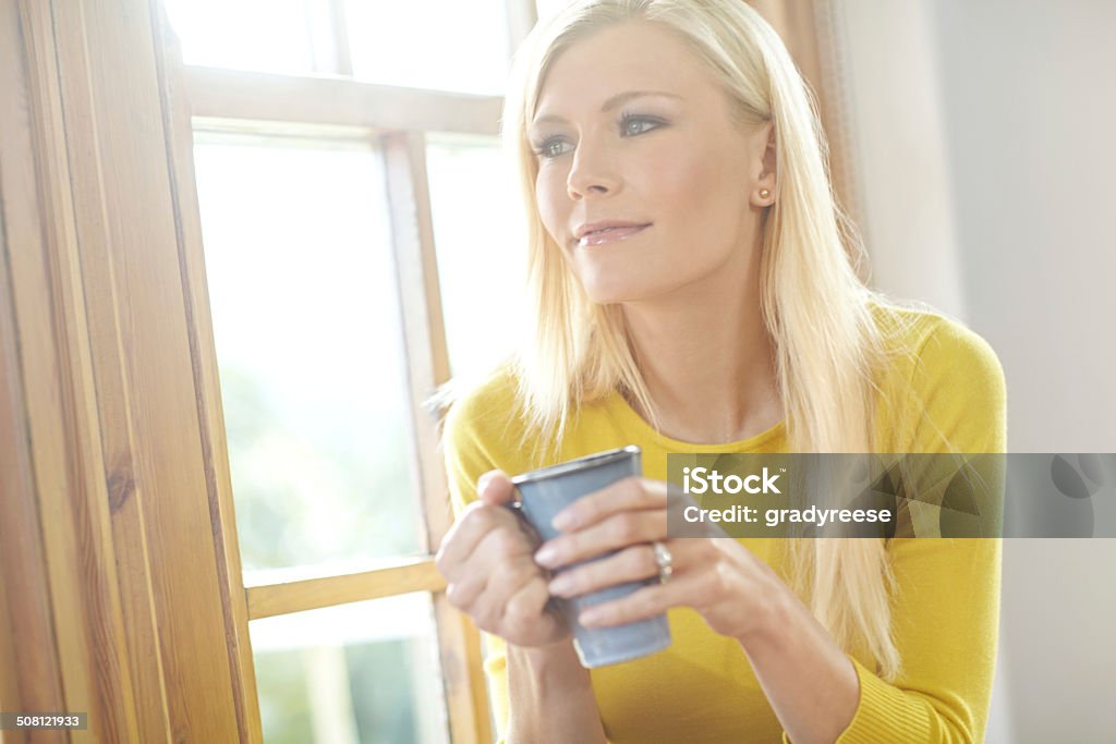 Starting the day just right Shot of a beautiful young woman enjoying a hot drink next to a window at homehttp://195.154.178.81/DATA/istock_collage/0/shoots/784643.jpg Coffee - Drink Stock Photo