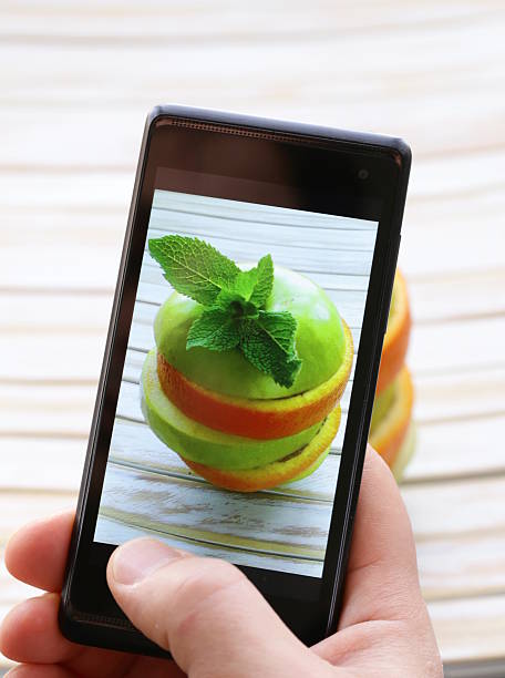 smartphone toma la foto-rodajas de naranja y manzana verde - apple portion red freshness fotografías e imágenes de stock
