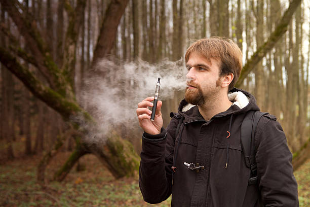istock man with the electronic cigarette in the park autumn 508125737