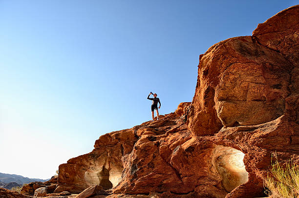 istock Trail runner drinking water above lit caves in rocks 508125811