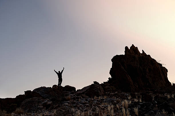 istock Man raises arms at skies at dawn 508125925