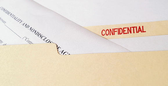 A legal confidentiality and non-disclosure agreement in a manila folder marked Confidential.