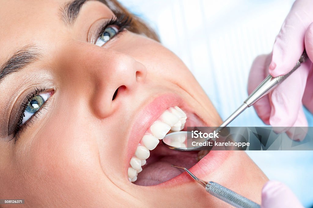 Dentist working on girls teeth Extreme close up of beautiful young girl having dental check up. Dentist Stock Photo